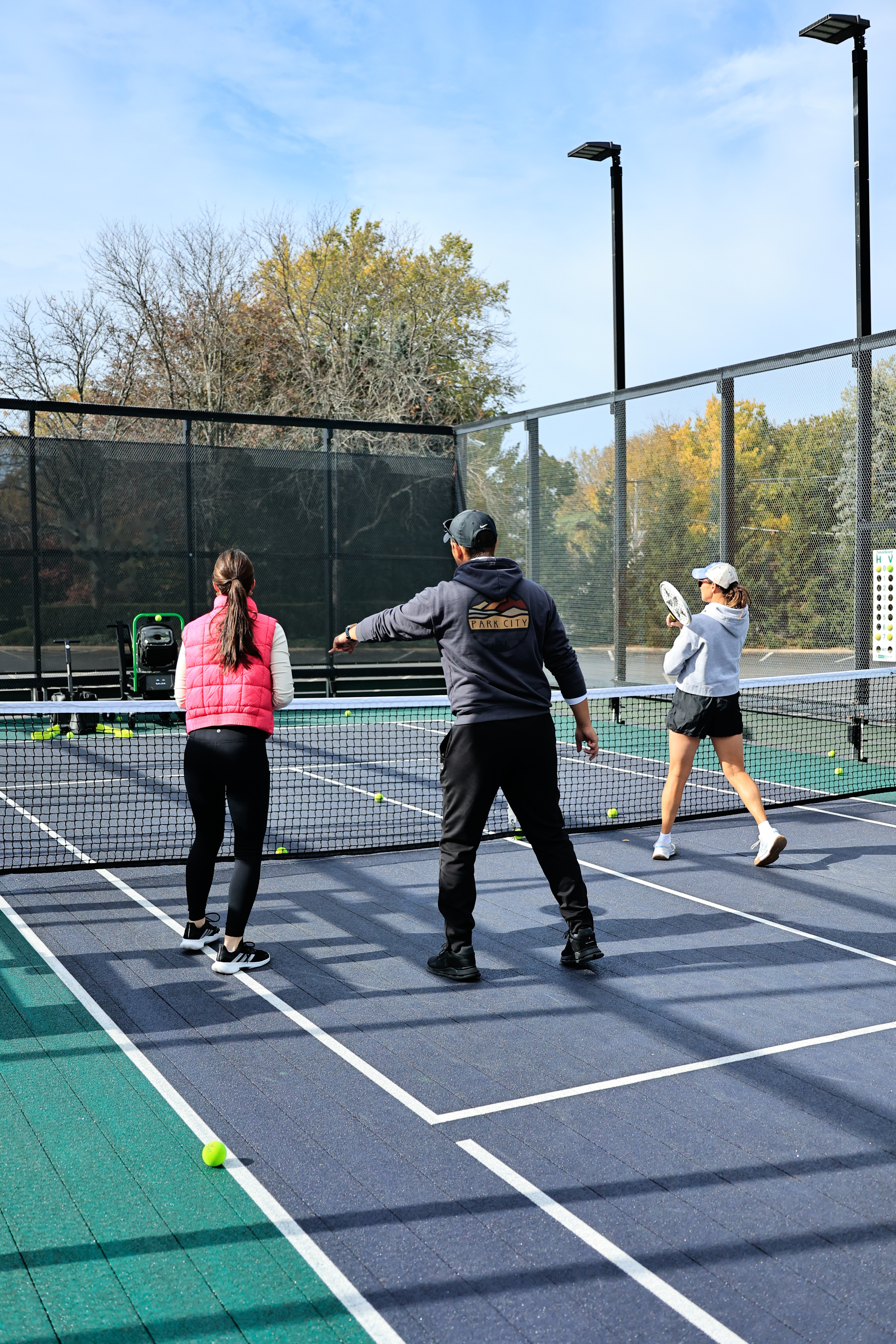 A pro coaching two players in a clinic on court
